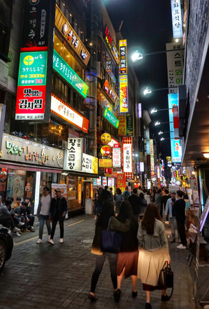 Seoul, South Korea - April 2018: Bright advertising on the walls, the mass of people on the shopping street, the nightlife of the city. Cityscape.のeditorial素材