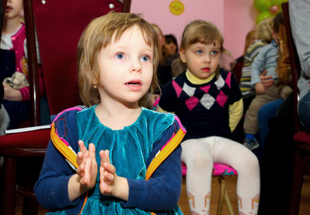 MOSCOW, RUSSIA - May 2017: The girl carefully watches the show and claps her hands at the spring festival.のeditorial素材