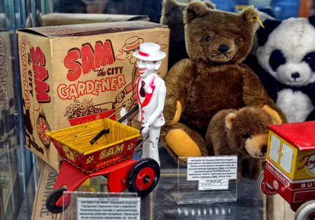 MOSCOW - MARCH, 2018: Clown with a garden wheelbarrow and a teddy bear. Showcase with old toys in a retro toy store.のeditorial素材