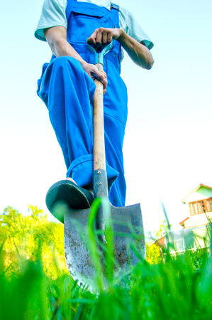 A man with shovel on green grass.の写真素材