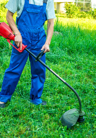 A man with a lawn mower on green grass.
