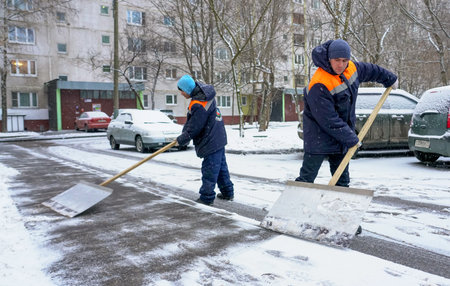 Moscow - January 2020: Workers in uniform with big shovels. Snow removal on the city streets.のeditorial素材