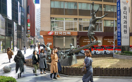 Seoul, Republic of Korea - March 2019: A modern sculpture in the center of Seoul, children swing happily on a swing. People walk past the installation.のeditorial素材