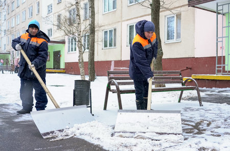 Moscow - January 2020: Workers in uniform with big shovels. Snow removal on the city streets.のeditorial素材