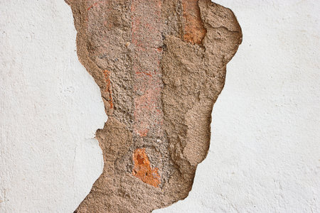 White walls with a tear until you see the brick inside.の写真素材