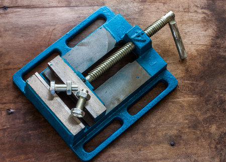 nut and bolt under the Pressure of Vice on Old wooden backgroundの写真素材