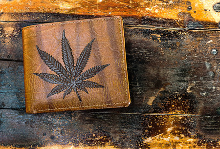 Brown wallet picture marijuana leaf on the old wooden floorの写真素材