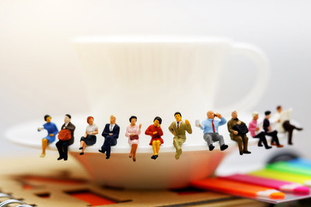 Miniature people: business team  sitting on cup of coffee,  break time of business concept.の写真素材