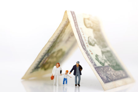 Miniature people: Family walking hand in hand with  bill, happy family day concept.
の写真素材