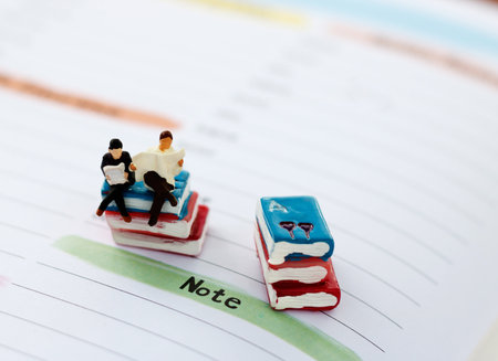 Miniature people reading and sitting on book, education or business concept.
の写真素材