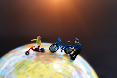 Miniature Father and Child with toy bicycle on world map, traveling, exploring the world, business concept.の写真素材