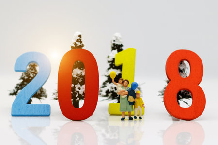 Miniature people, mother and children with colorful balloons standing in front of number 2018, Family concept.の写真素材
