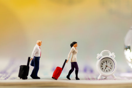 Traveling or business trip concepts. Miniature people with baggage walking on passport and clock. 
の写真素材