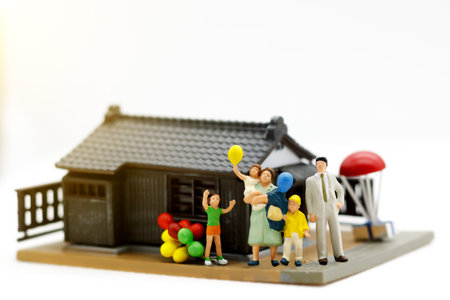 Miniature people, parents and children holding balloon with home ,family day concept.の写真素材