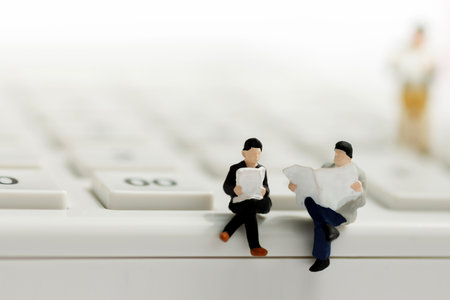 Miniature businessman reading on calculator, education and business concept.の写真素材