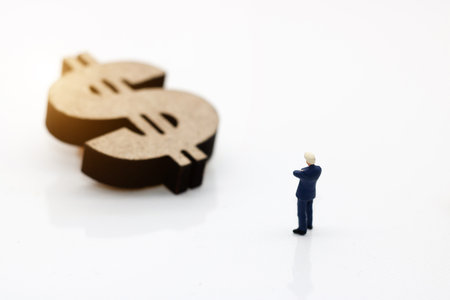 
Miniature people: Businessman looking dollor sign. Finance and growth in business conceptの写真素材