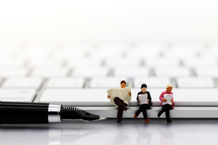 Miniatures people reading with keyboard, education or business concept.
の写真素材