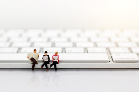 Miniatures people reading with keyboard, education or business concept.の写真素材