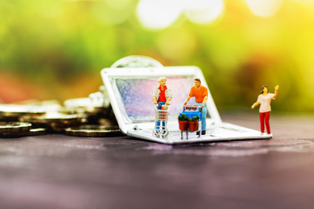 Miniature people  with shopping cart on notebook. travel or business  concept. 
の写真素材