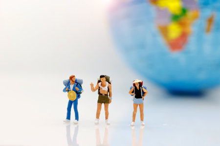 Miniature people, backpackers with globe walking to destination. Concept of Travel around the world...