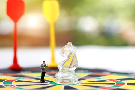 miniature people reading with glass chess on the dartboard. Target business concept.の写真素材