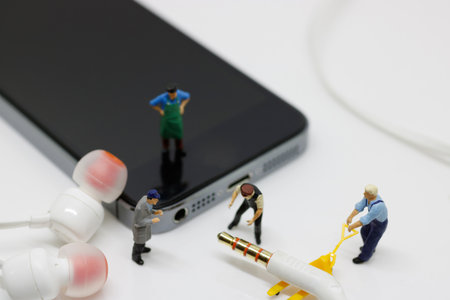 Miniature worker team are doing connected cable earphone jack to the smartphone for listen music.Communication, technology and musicians concept.の写真素材