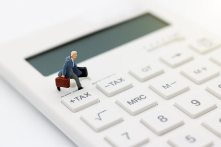 Miniature people, businessman running on calculator with tax button,  Tax, financial and business concept.の写真素材