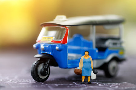 Shopping concept, Miniature woman with shopping bags on the map and tricycle or Thai tuk tuk.の写真素材