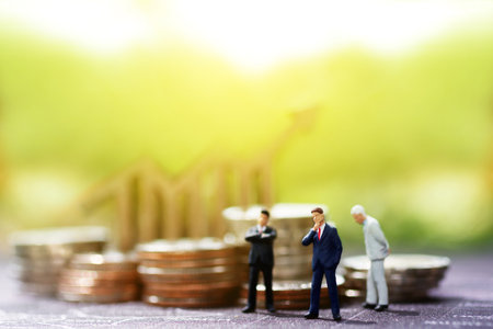 Miniature businessman with coin and graph, Finance, investment and growth in business concept.の写真素材
