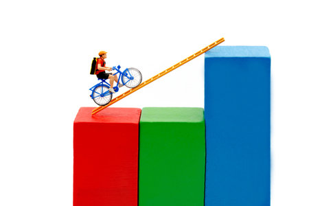 Miniature people: Traveler riding bicycle on wood ladder with growth graph, Concept of the path to...