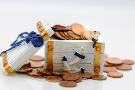Miniature people: Businessman sitting on block with coins. Business and education concept.