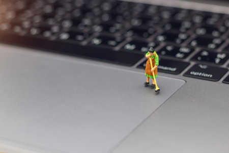 Miniature women cleaning  pointing device laptop. Concept of cleaning viruses computer, security and technology .の写真素材