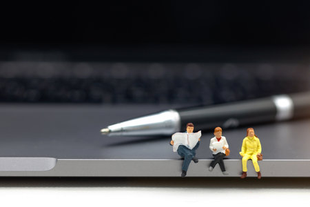 Miniatures people reading with keyboard, education or business concept.の写真素材