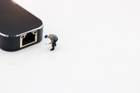 Miniature people: Worker fixing LAN port. Concept of network troubleshoot supporter or maintenance.の写真素材