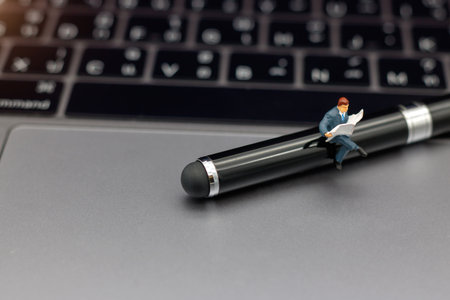 Miniatures people reading with keyboard, education or business concept.