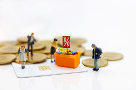 Miniature people: Shoppers buy goods on sale with discount tray on credit card and coins. Concept of tourism, shopping or business.の写真素材