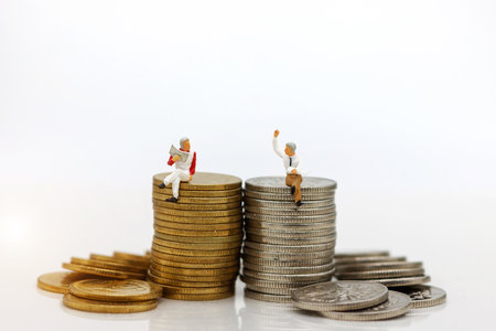Miniature people: Businessman sitting on coins stack. Education and business concept.