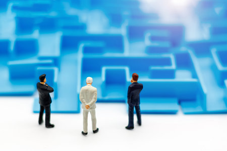Miniature people: Businessman standing on start of maze. Concepts of finding a solution, problem solving and challenge.の写真素材