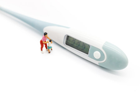 Miniature people: Mother and children meet doctor with thermometer. Health care and business concept.の写真素材