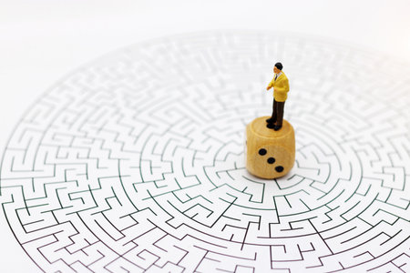 Miniature people: Businessman standing on center of maze. Concepts of finding a solution, problem solving and challenge.の写真素材