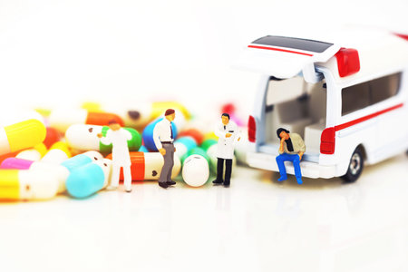 Miniature people: Doctor and patient standing with ambulance  and drugs. Health care and emergency concept.の写真素材