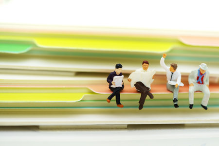 Miniature people: Business team reading book, education or business concept.の写真素材
