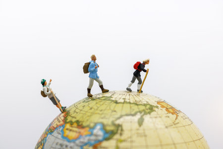 Miniature people: Traveller with backpack walking on the path of tourism. Travel, explore and adventure conceptの写真素材