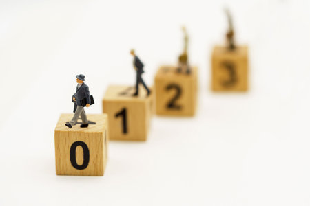 Miniature people : Businessmen standing on the wood block with sequence number. Concept of the business career growth.の写真素材
