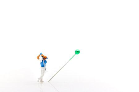Miniature people: Golfers hit golf balls forward. Target and growth in business concept.の写真素材