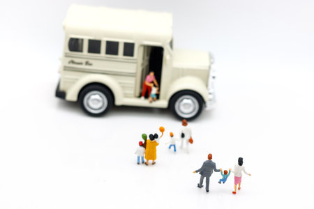 Miniature people: Childrens getting on the schoolbus with teacher.