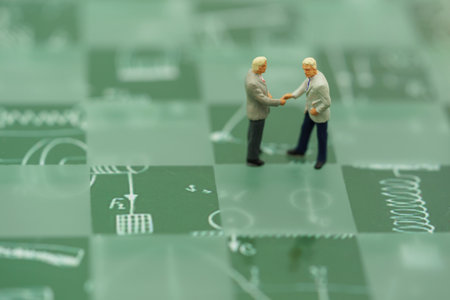Miniature people: Businessmen handshake with green background, agreement, partnership and business...
