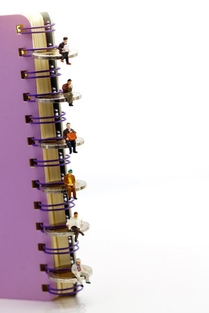 Miniature people: Business team reading book  on coins stack, education or business concept.の写真素材
