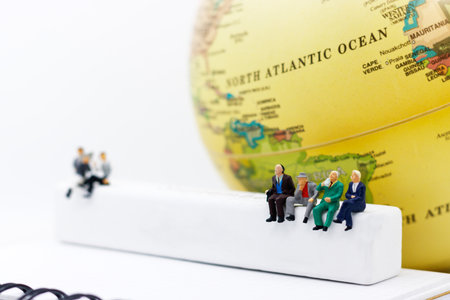 Miniature people: Business team reading book on white wooden box with globe. education or business concept.の写真素材