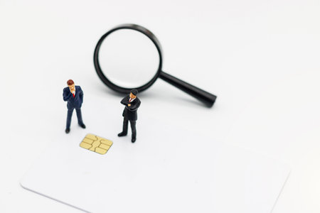 Miniature people: Businessman stading with Chip Cards and Magnifiers. Credit card payment and shopping, e-commerce, bank technology online concept.の写真素材